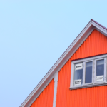 a red house with a white framed window. Five signs in the window read: "Breathe.", "This is hard.", "Be kind to yourself." "You are resilient.", and "#RecoveryMovement"